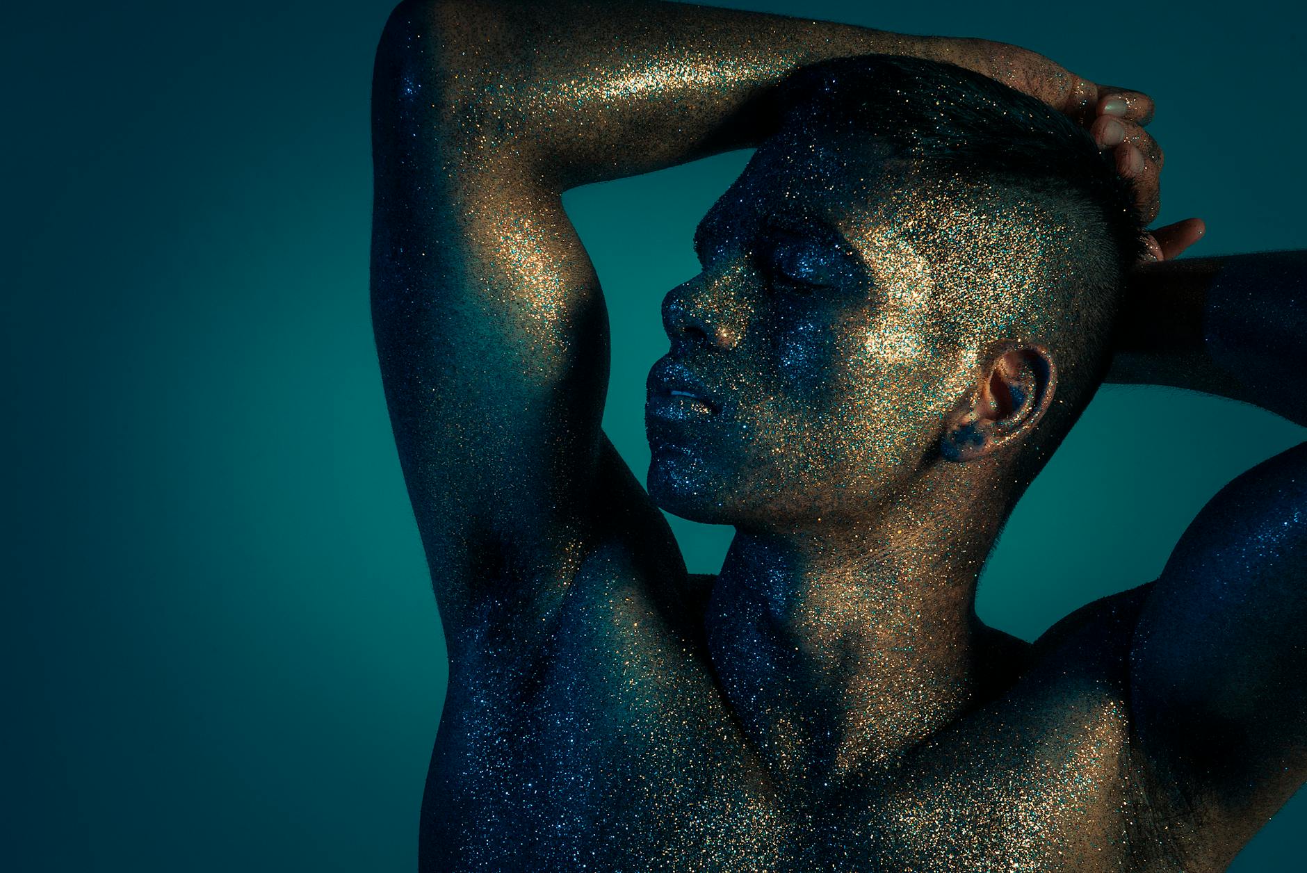 Mężczyzna w brokacie na tle niebieskiego studia fotograficznego