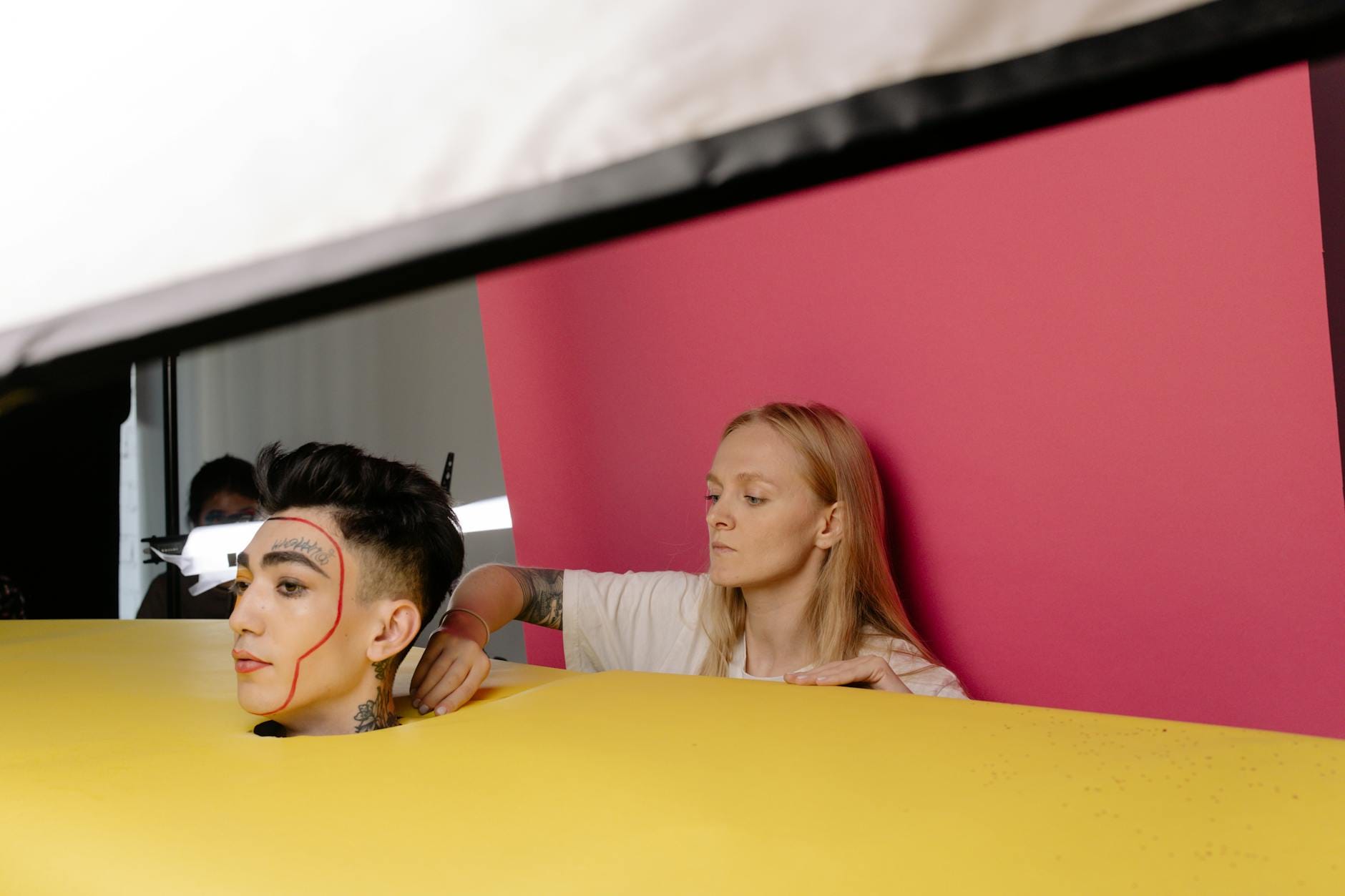 Modelka w studiu z artystycznym makijażem na tle kolorowej scenografii