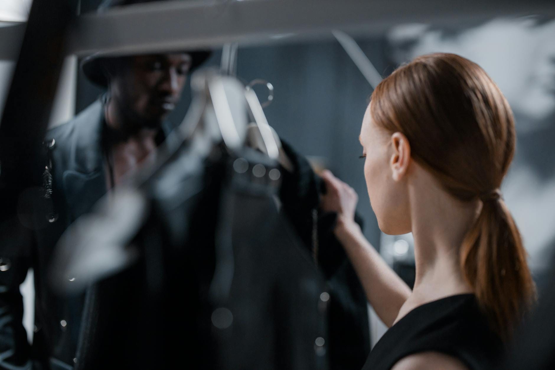 Projektant mody pomaga modelce dobrać elegancki strój do sesji