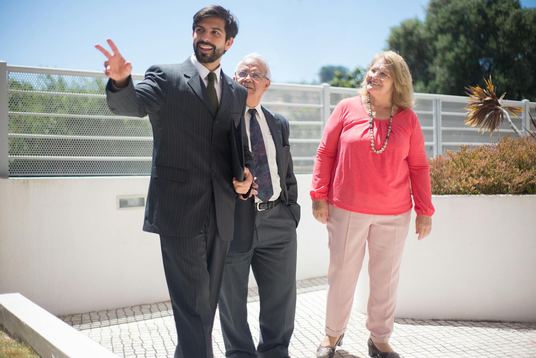 Agent nieruchomości pokazuje dom starszej parze na zewnątrz