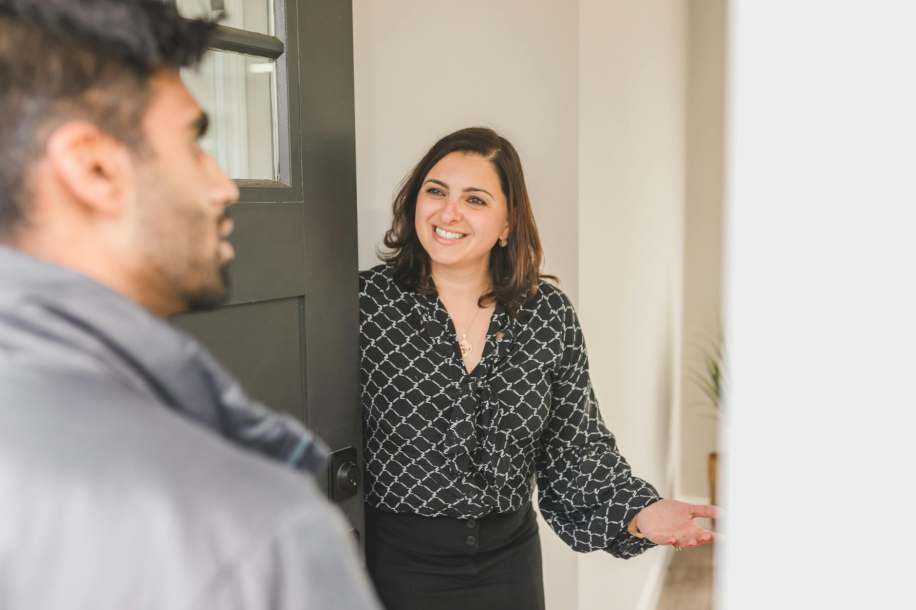 Agent nieruchomości wita klienta w nowoczesnym mieszkaniu