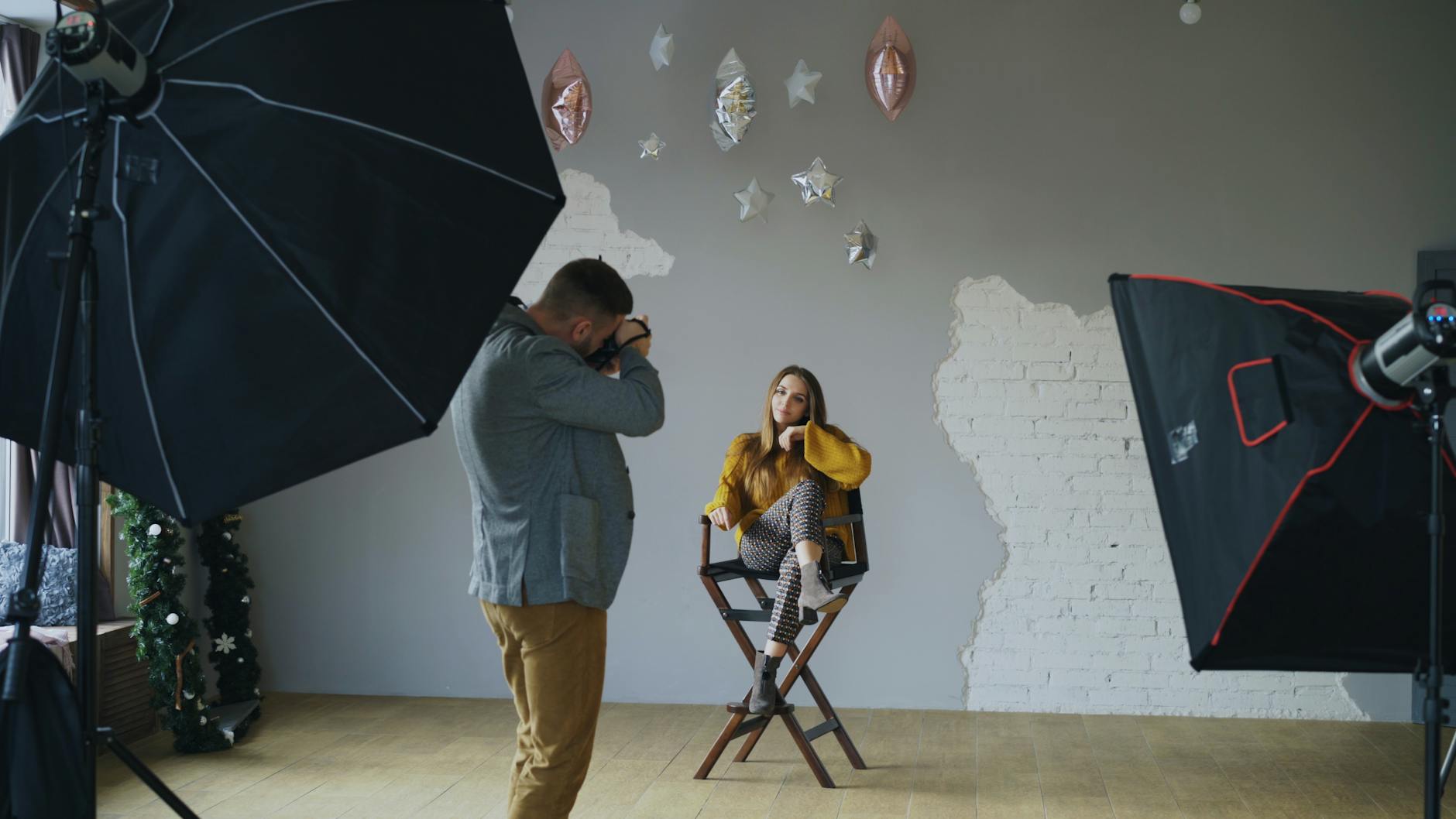 Fotograf w studiu portretuje modelkę przy oświetleniu i blendzie