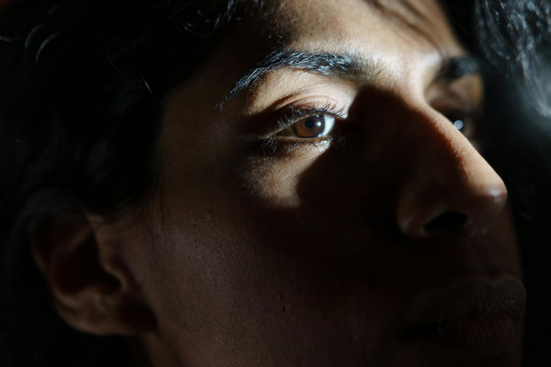 Kobiecy portret z bocznym światłem i mocnymi cieniami na twarzy