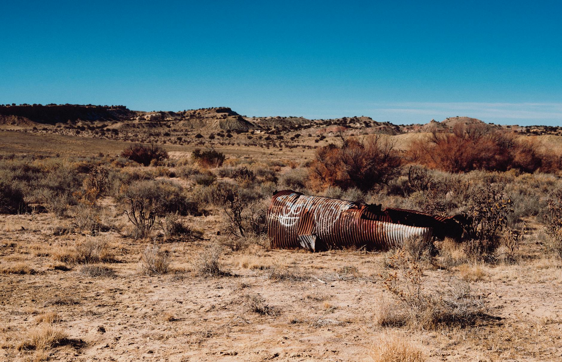 Zardzewiała rura na suchym pustynnym terenie pod bezchmurnym niebem