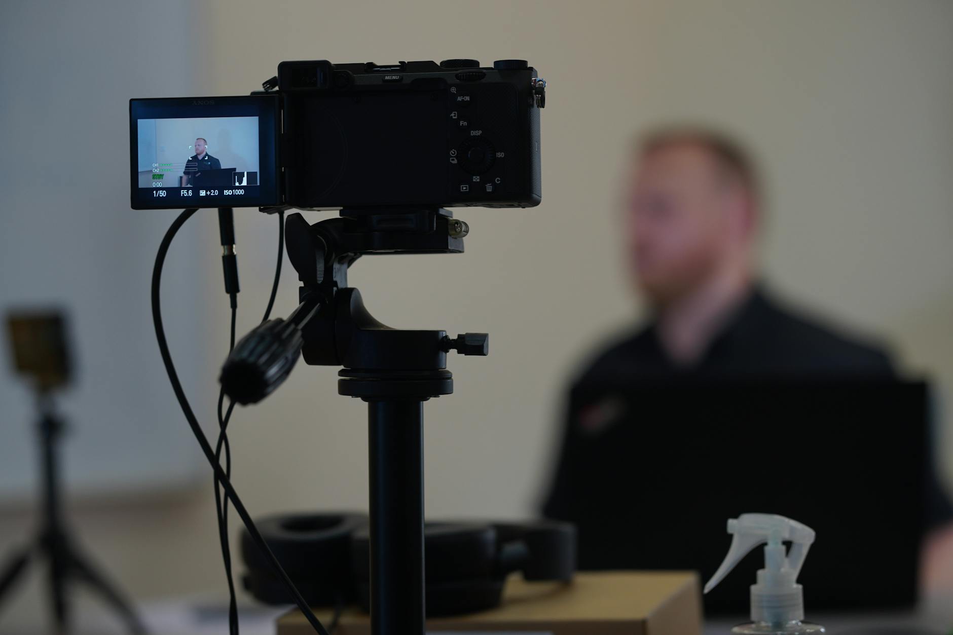 Zbliżenie na aparat nagrywający prelegenta w tle podczas nagrań