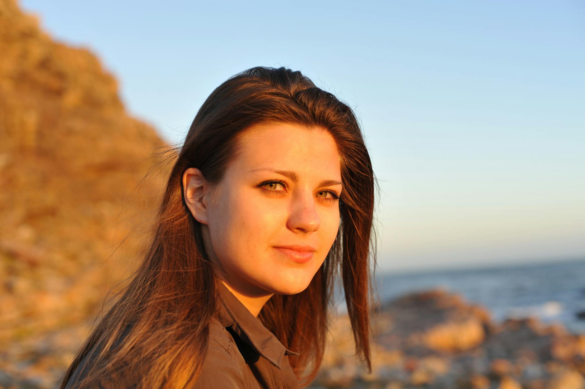 Portret młodej kobiety na plaży o zachodzie słońca, horyzont nad głową