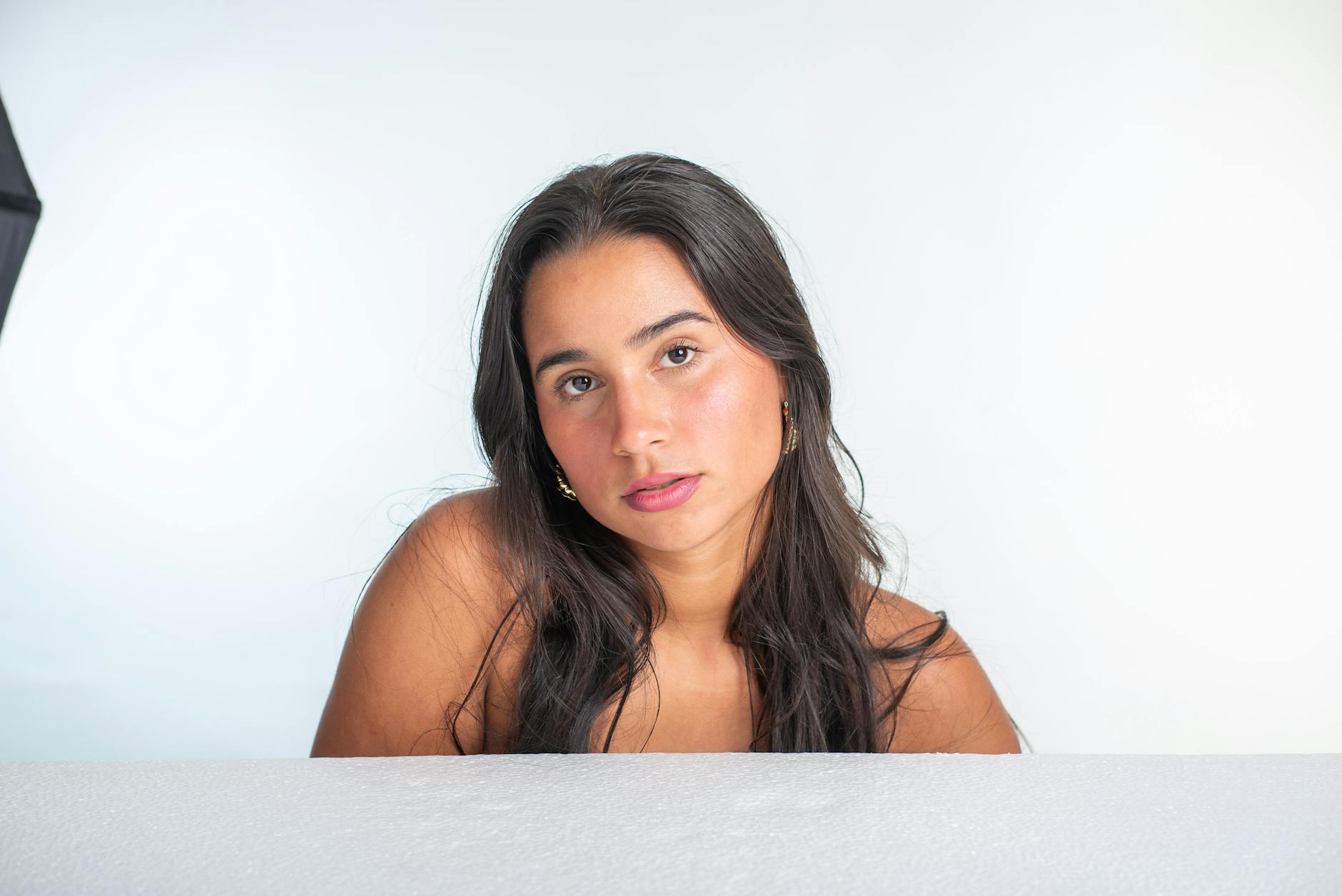 Zbliżenie młodej kobiety na gładkim, jasnym tle w studio