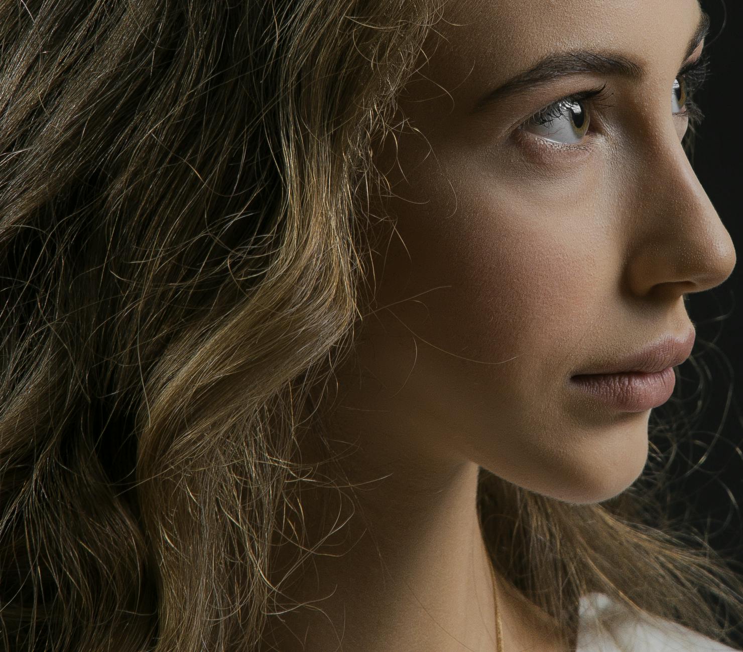 Zbliżony profilowy portret blondynki z wyraźnymi detalami twarzy