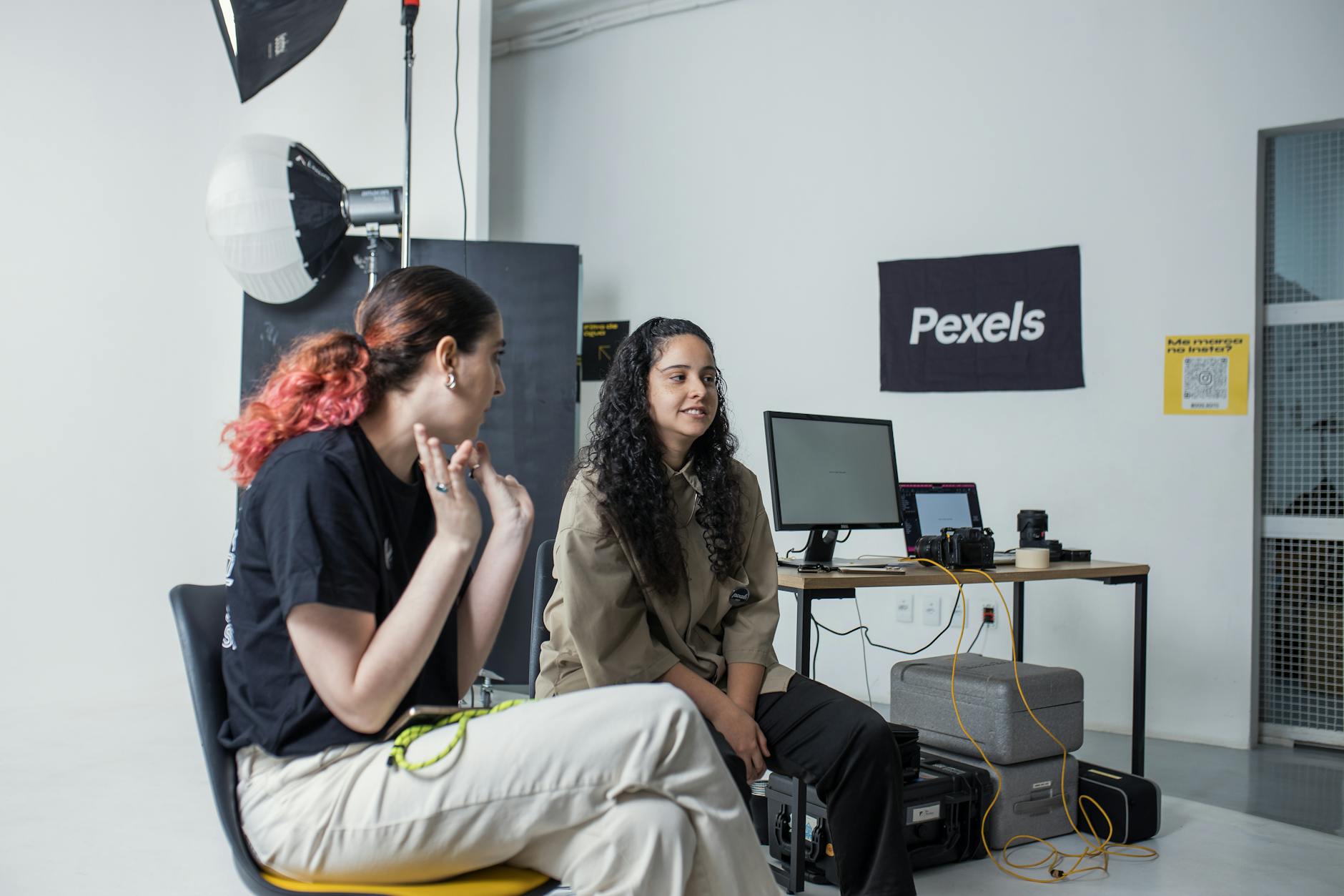 Dwie fotografki omawiają wybór ujęć w profesjonalnym studiu Dwie fotografki omawiają wybór ujęć w profesjonalnym studiu