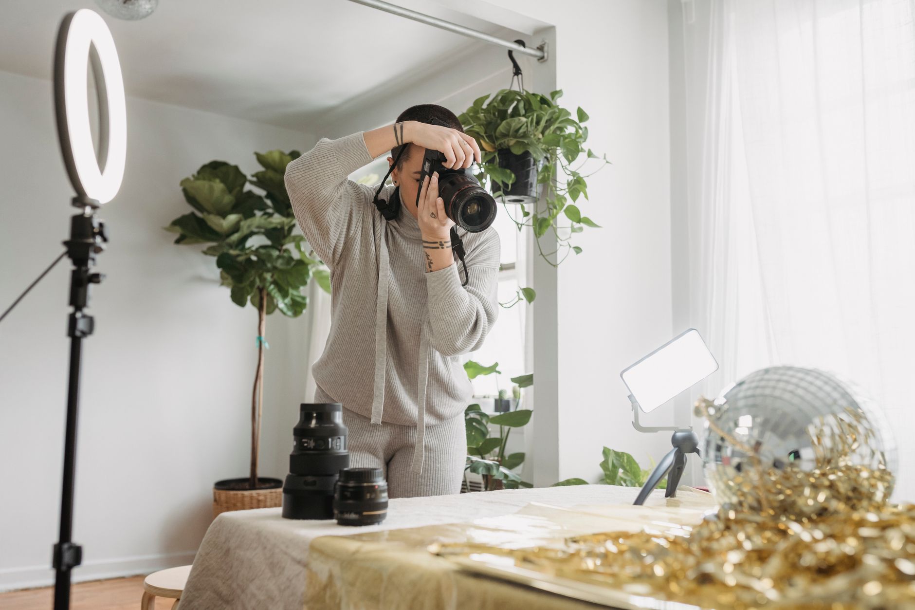 Fotografka z aparatem przygotowuje scenę z kulą dyskotekową i dekoracją Fotografka z aparatem przygotowuje scenę z kulą dyskotekową i dekoracją
