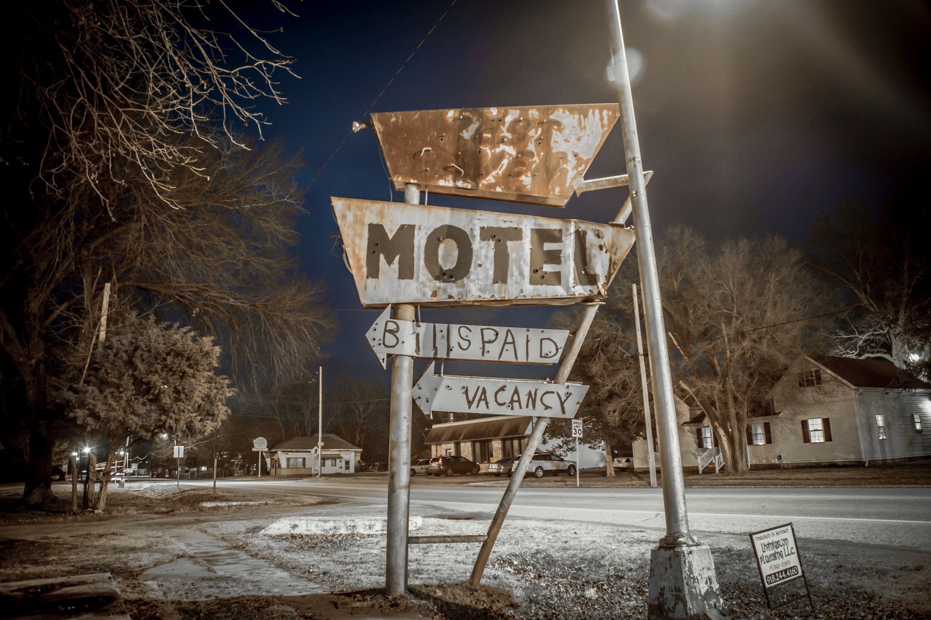 Nocny widok na stary szyld motelu przy pustej ulicy miejskiej