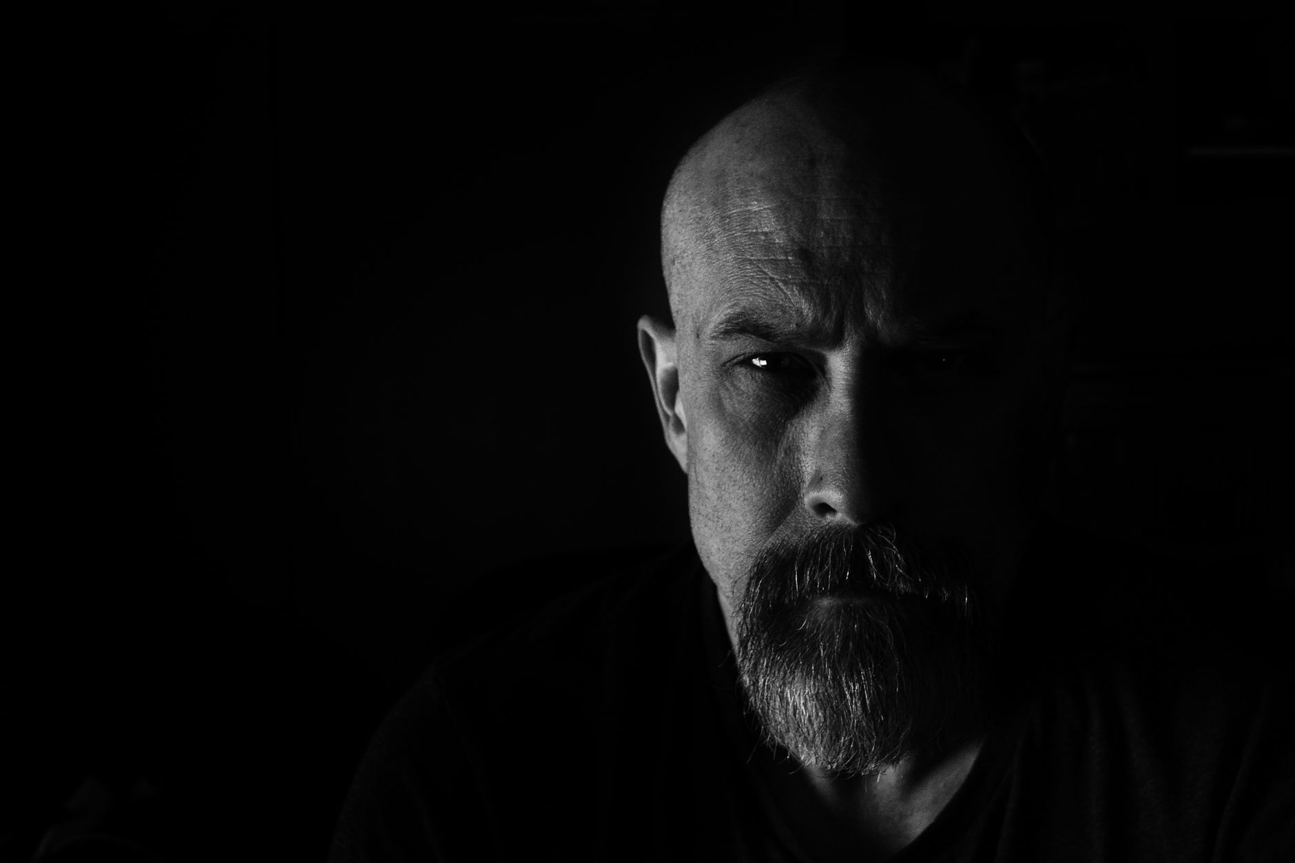 Czarno-biały portret brodatego mężczyzny w dramatycznym, low key oświetleniu