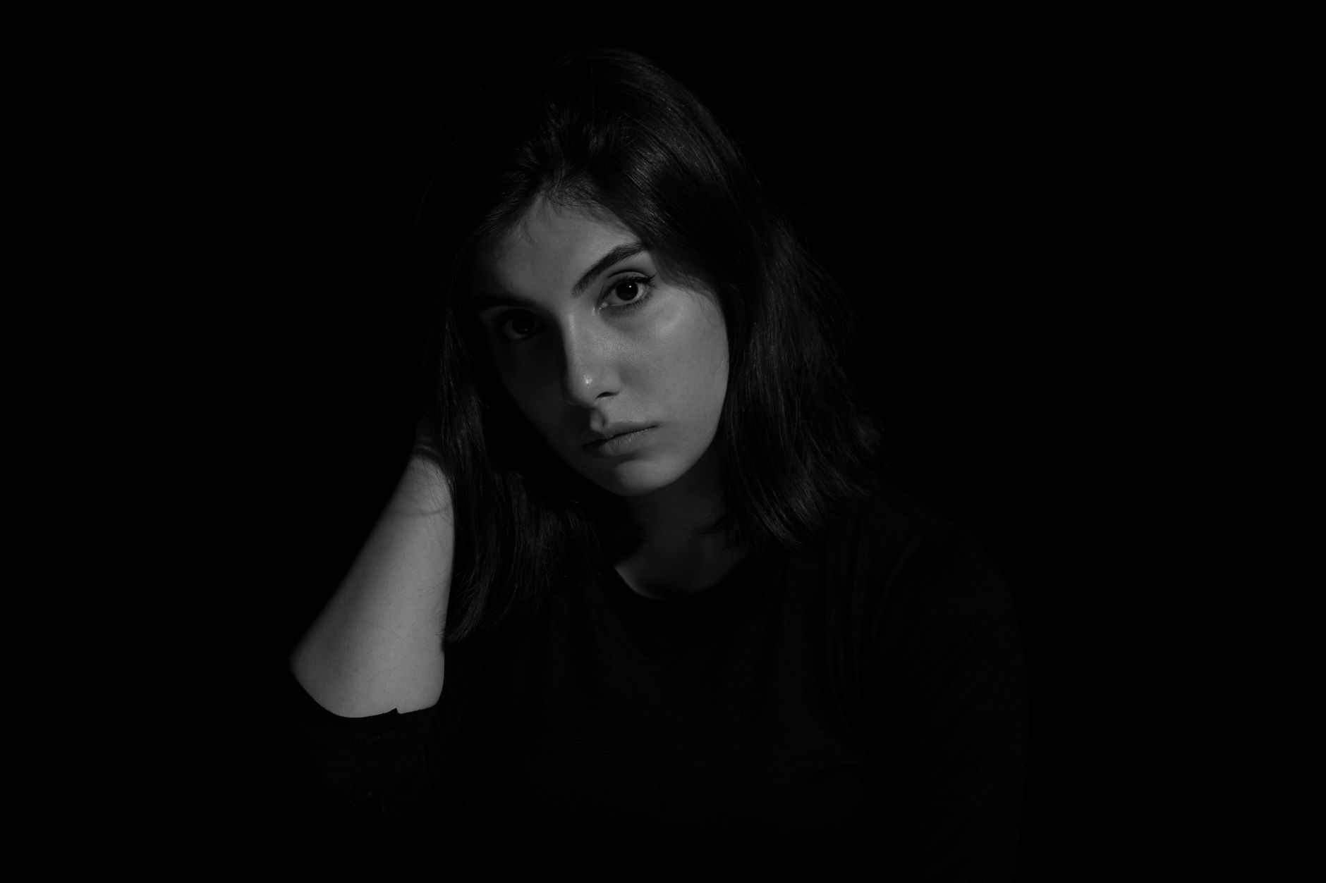 Czarno-biały portret kobiety w stylu low key na ciemnym tle Czarno-biały portret kobiety w stylu low key na ciemnym tle