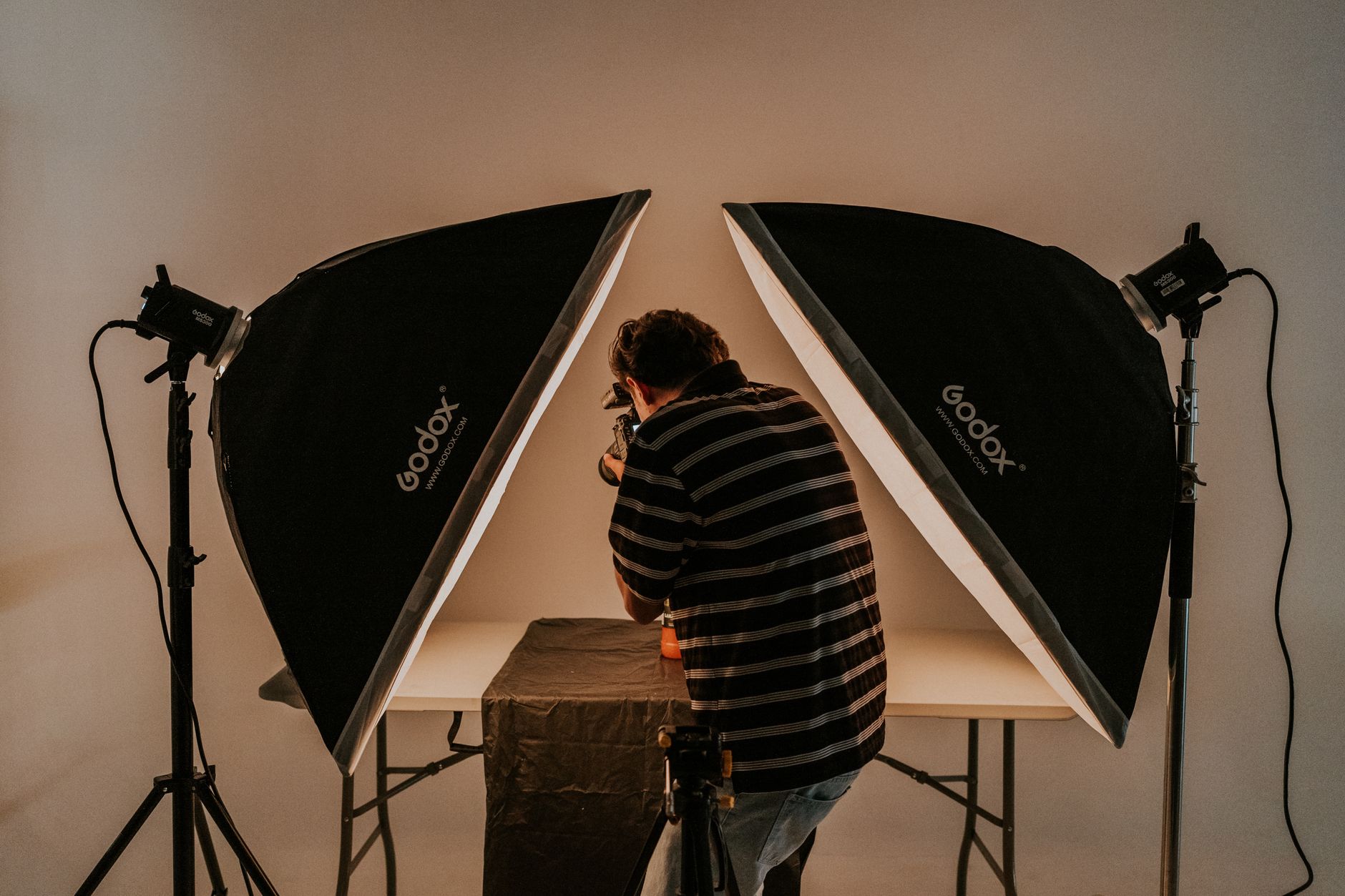 Fotograf w studiu korzystający z oświetlenia ciągłego i softboksu