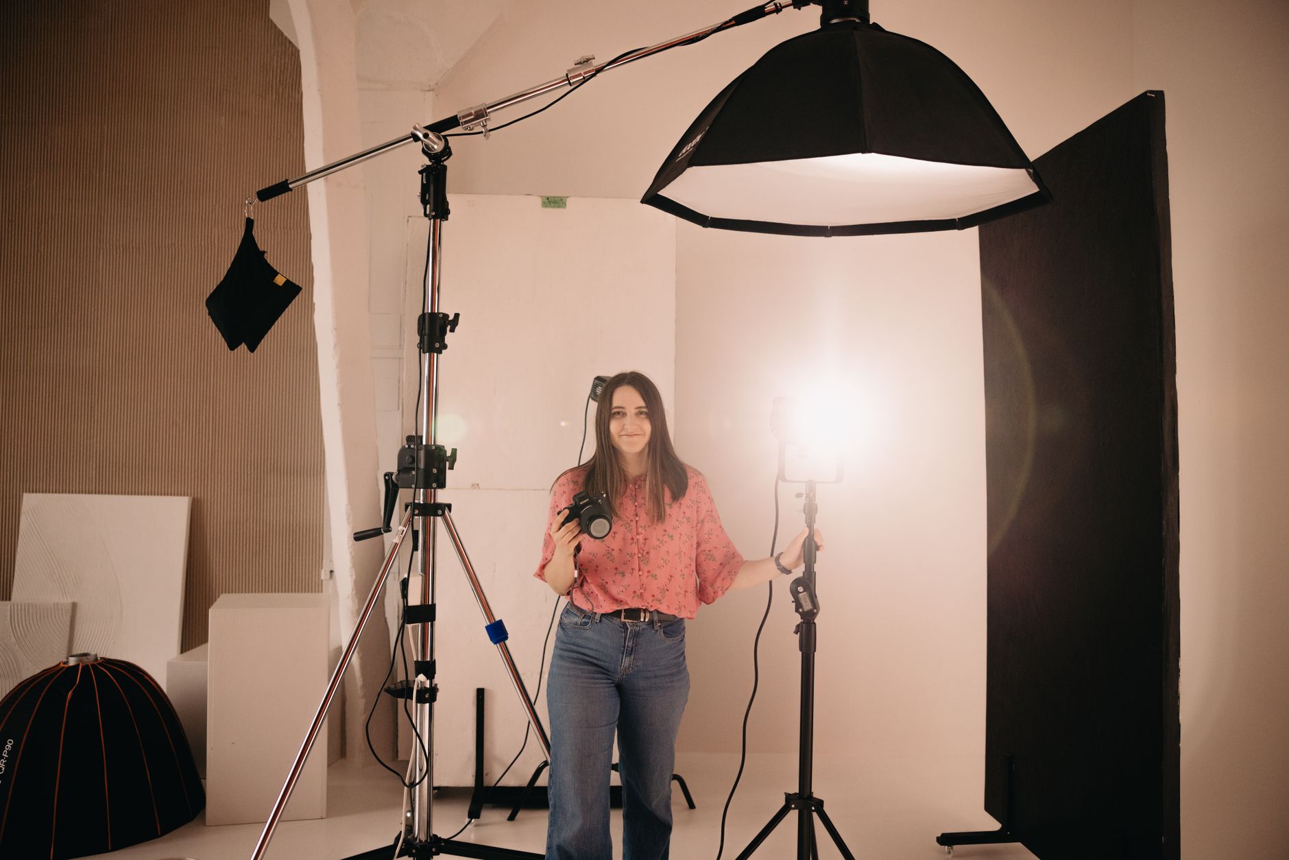 Fotografka w studiu z aparatem i lampami światła ciągłego